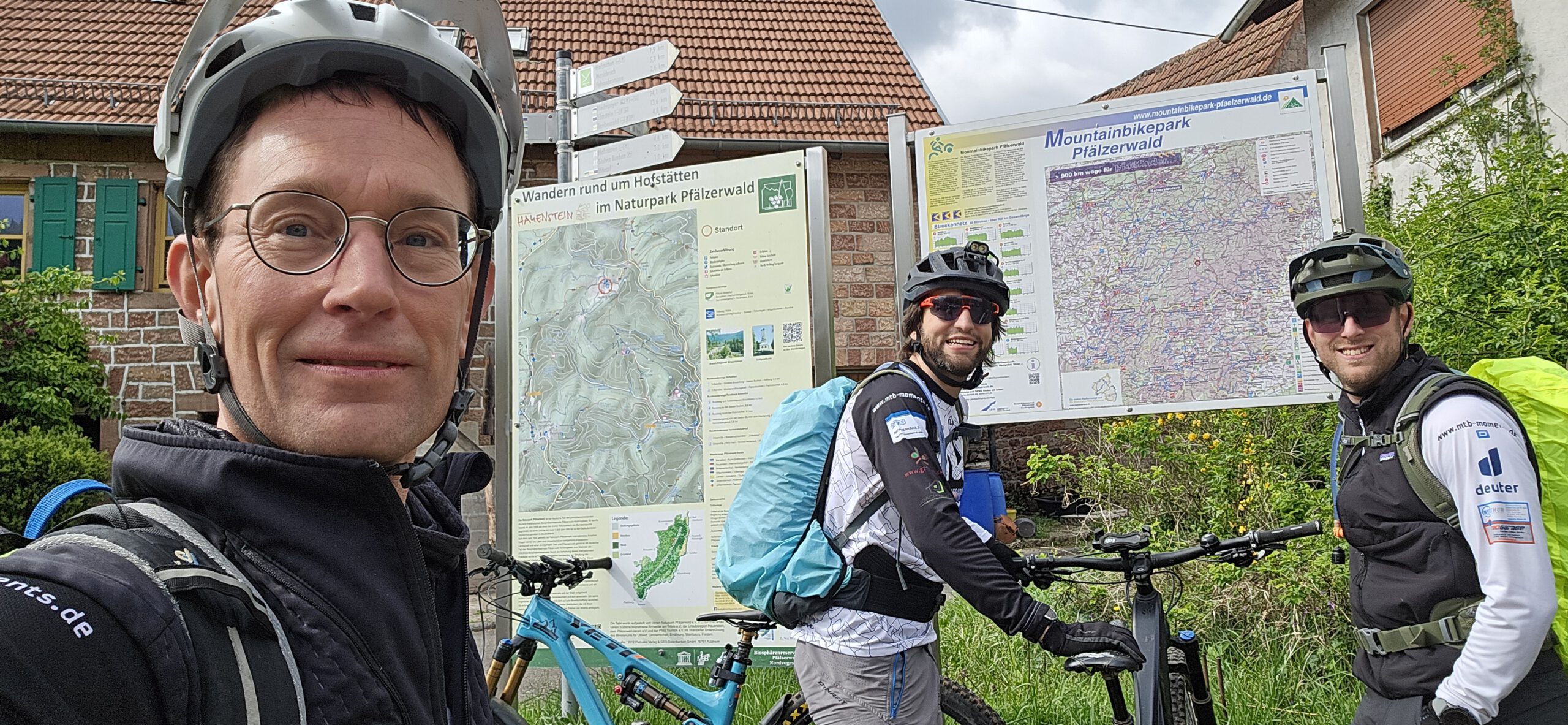 Michaque Kaiser, Klaus Stark und Martin Strauß bei der Orientierung auf einer Karte vom Mountainbikepark Pfälzerwald
